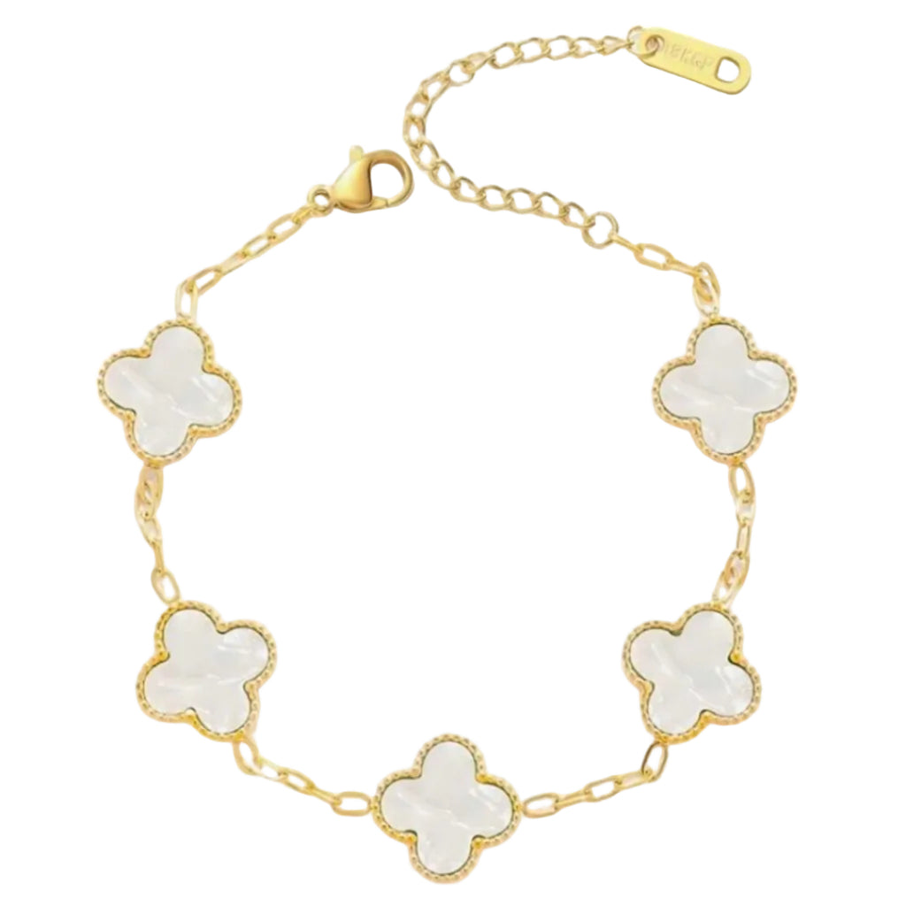 Gold bracelet with white flower-shaped charms on a white background