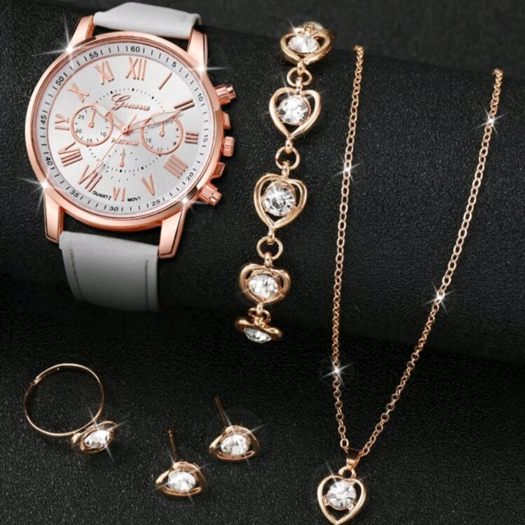 Rose gold watch, bracelet, necklace, and ring on a black background