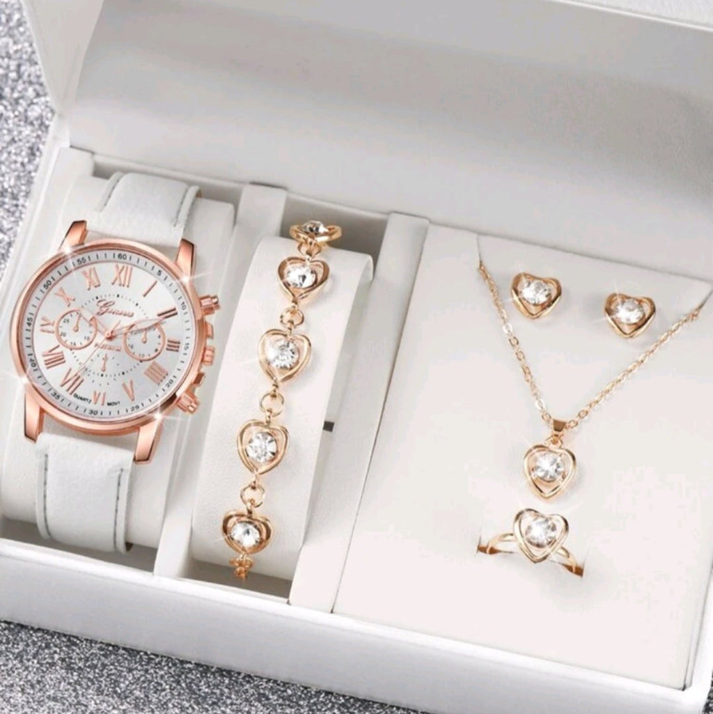 Set of jewelry including a watch, bracelet, necklace, and earrings on a white background in a box